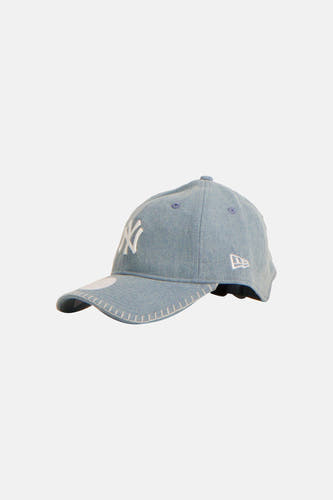 Casquette bleue de NEW ERA, avec un logo blanc des Yankees et des surpiqûres décoratives sur la visière.