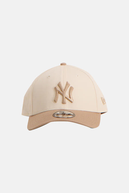 Beige pet van New Era met een geborduurd logo aan de voorkant.
