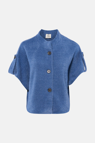 Cardigan bleu de Terra di Siena à manches courtes et fermeture boutonnée, porté avec un jean.