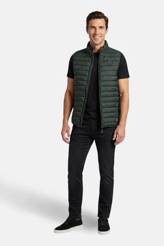 Kaki bodywarmer van Cars, gedragen over een zwart T-shirt en een zwarte jeans met suède schoenen.
