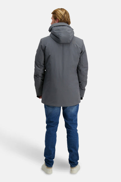 Lange grijze jas van Cars, met capuchon, gedragen over een blauwe jeans en crèmekleurige schoenen, gezien van achteren.
