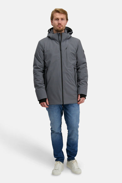 Lange grijze jas van Cars, met capuchon en een rits, gedragen over een spijkerbroek en witte sneakers.
