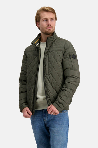 Manteau vert court de Cars, avec un motif à carreaux, associé à une chemise verte claire et des jeans bleus.