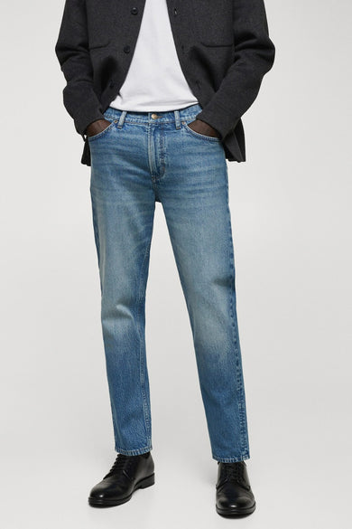 Tapered jeans in denim van MANGO, met een lichte wassing en zwarte schoenen.
