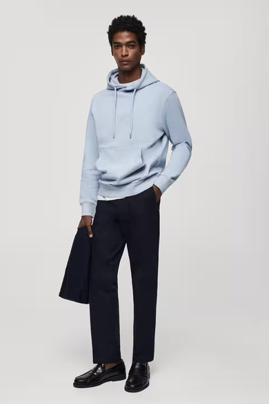 Blauwe sweater met kap van MANGO, gecombineerd met een donkere broek en leren schoenen.