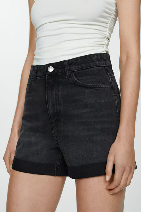 Short en denim noir de MANGO, avec un revers et une chemise blanche.