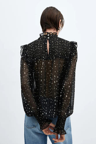Blouse noire de MANGO avec des manches longues, un motif à carreaux, des volants sur les épaules et un détail plié.