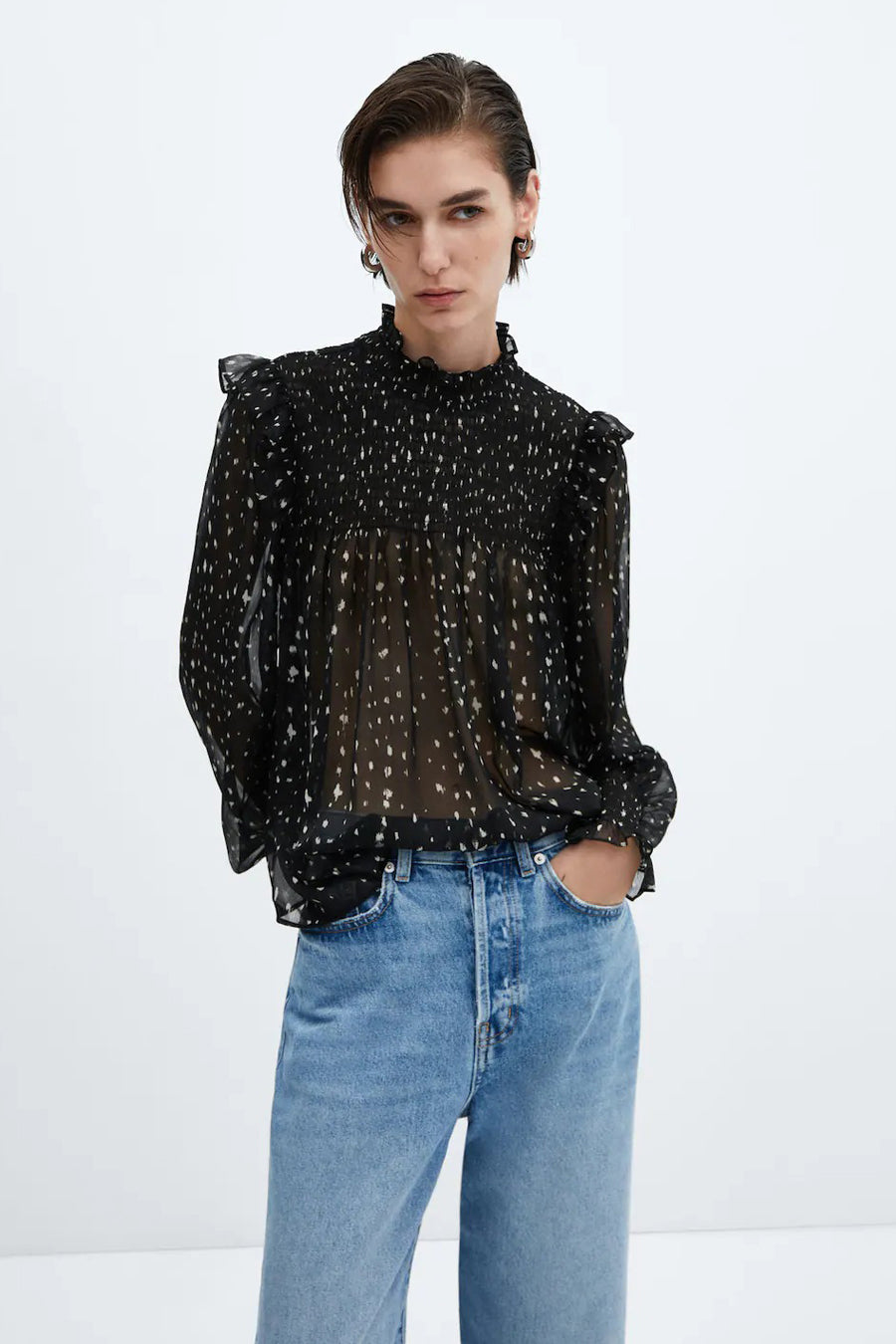 Blouse noire de MANGO, à longues manches et à carreaux, associée à un jean bleu.