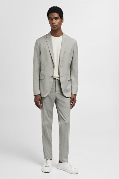 Groene blazer van MANGO, met lange mouwen en een knoopsluiting, gecombineerd met een wit shirt en witte sneakers.