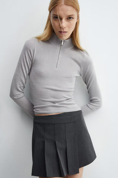 T-shirt en argent de MANGO, avec des manches longues, associé à des short noirs et des chaussures blanches, vue arrière.