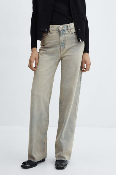 Jean large délavé de MANGO, taille haute, ourlets bruts et chaussures noires.