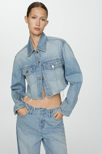 Jeansjas in middeldonkerblauw denim van MANGO, met gerafelde zoom en gedragen met een bijpassende jeans.
