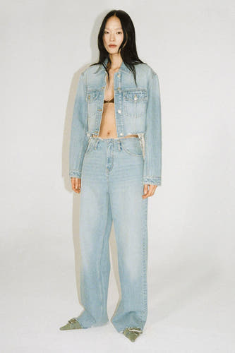 Denim jas in mid blue denim van MANGO, gedragen met een bijpassende jeans en groene schoenen.