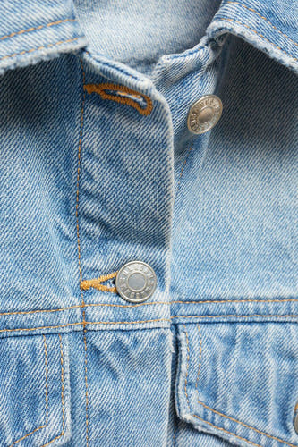 Jeansjas van blauw denim van MANGO, met zilverkleurige knopen en bruine stiksels.