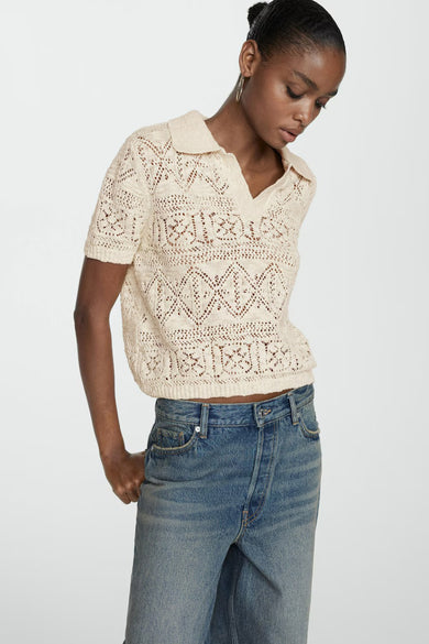 Beige gebreide pull met ronde hals van MANGO, met openwerk patroon en korte mouwen, gedragen met blauwe jeans, zijprofiel.