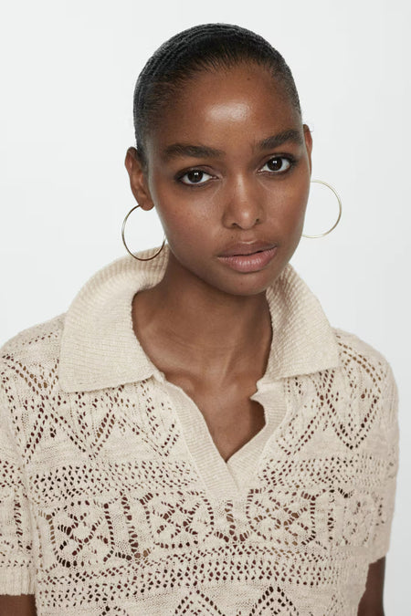 Beige gebreide pull met ronde hals van MANGO, luchtig openwerkpatroon, korte mouwen, model in close-up voorzijde