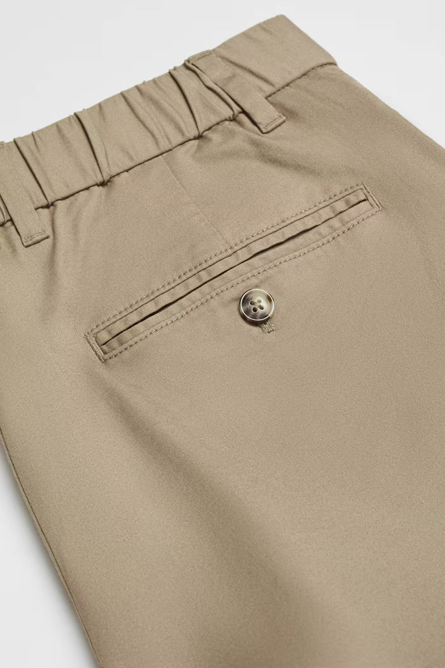 Bruine korte broek van MANGO met elastische tailleband en paspelzak met knoopdetail.