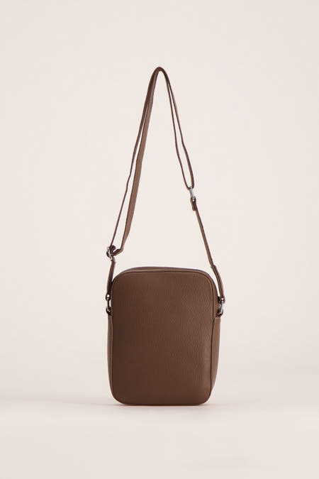 Sac à dos marron de MANGO, avec une texture structurée et une longue sangle d'épaule ajustable.