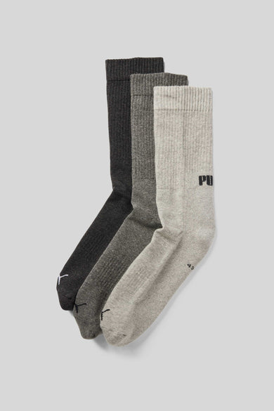 Grijze sokken van PUMA met logo en subtiele geribbelde texturen, in drie tinten grijs.
