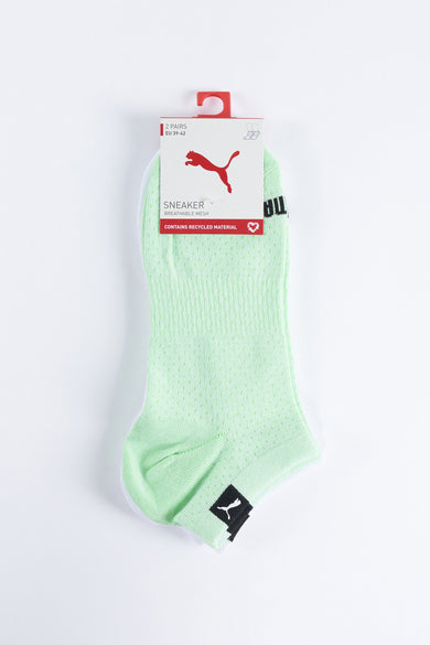 Chaussettes vertes de PUMA, avec un motif de petits trous et un logo noir.