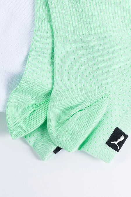Groene sokken van PUMA, met een patroon van kleine gaatjes en een zwart logo.