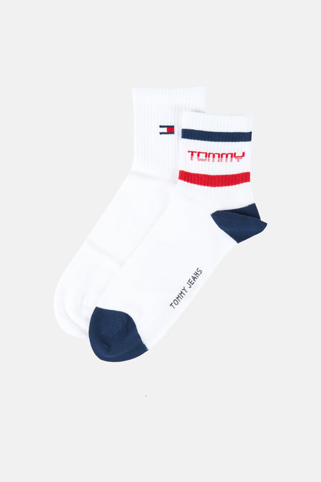 Chaussettes blanches (multipack) de Tommy Jeans, avec des accents bleu foncé sur les orteils et le talon, ainsi que le nom de la marque et des rayures.