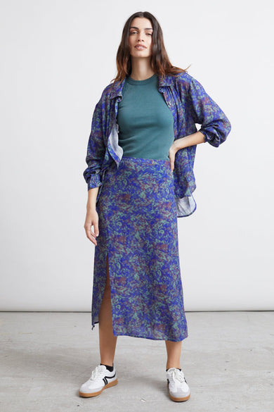 Robe bleue de 24 couleurs, avec un motif abstrait et une fente à l'avant, associée à un t-shirt et des baskets.
