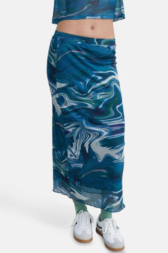 Blauwe rok van 24 colours met een gemarmerd patroon, gecombineerd met witte sneakers en groene sokken.