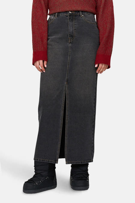 Jupe en denim gris foncé de 24 Colours GMBH, avec une fente à l'avant et des moon boots noires.