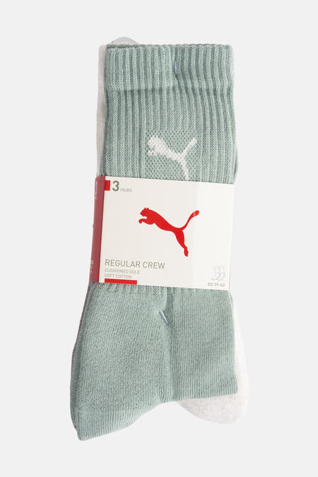 Chaussettes vertes de PUMA, emballées par trois paires, avec un logo blanc sur la tige.