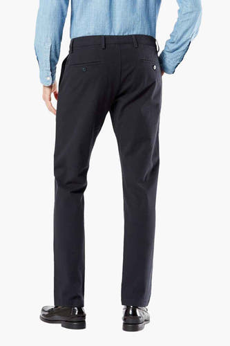 Blauwe chino van DOCKERS, gezien van achteren, gecombineerd met een lichtblauw overhemd en zwarte schoenen.