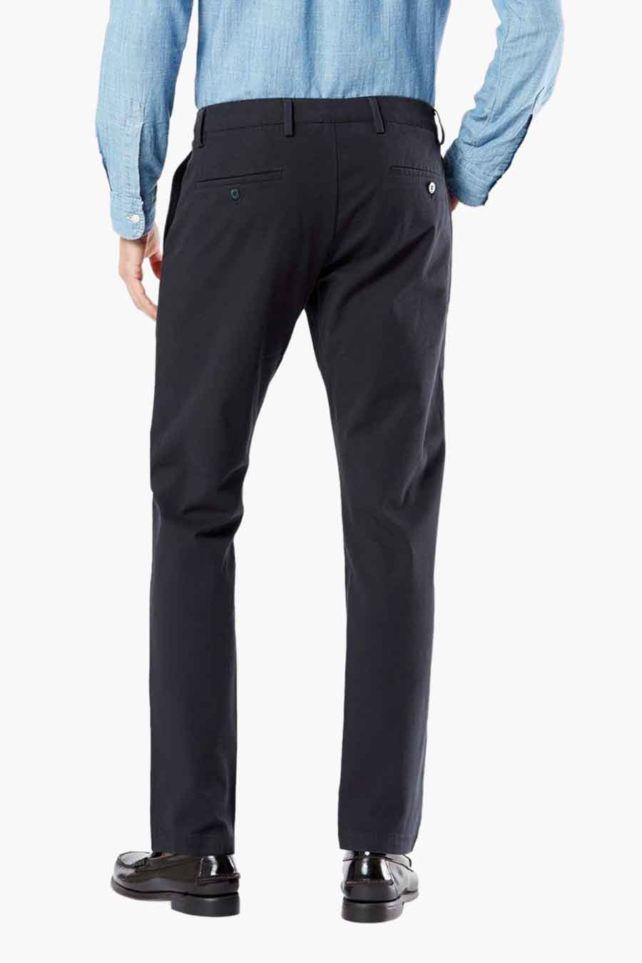 Blauwe chino van DOCKERS, gezien van achteren, gecombineerd met een lichtblauw overhemd en zwarte schoenen.