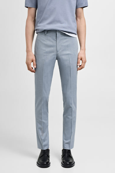 Blauwe kostuumbroek van MANGO, met persplooien en zwarte leren schoenen.