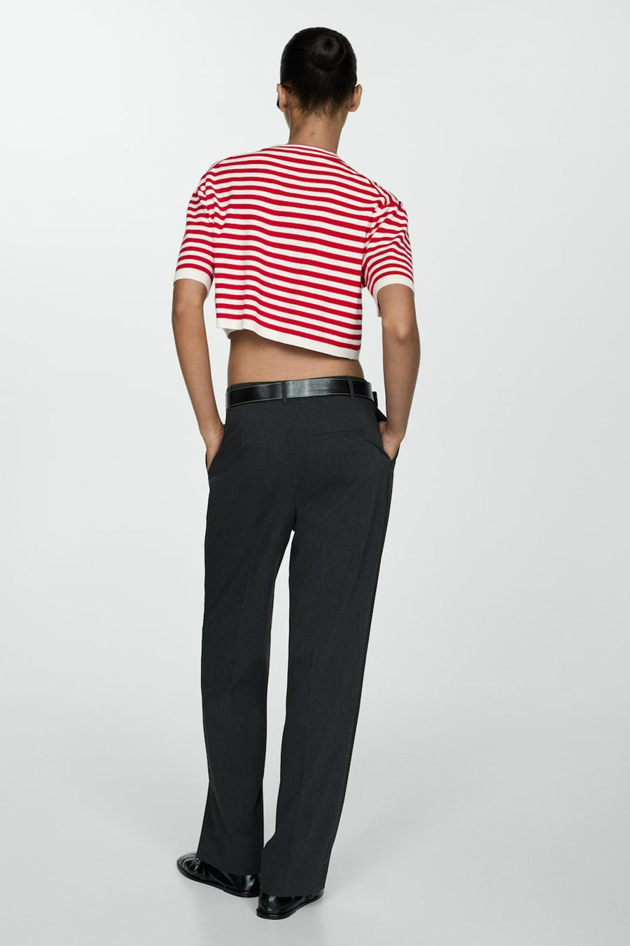 Rode trui met ronde hals van MANGO, met witte strepen, gecombineerd met een zwarte broek en schoenen.