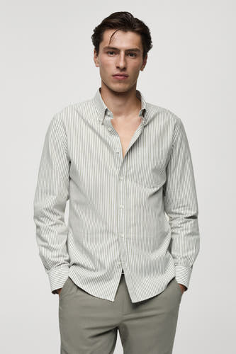 Chemise verte à manches longues de MANGO, rayée, dos nu, associée à un pantalon gris.