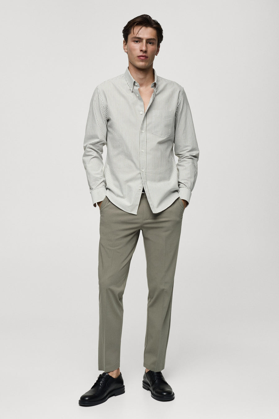 Chemise rayée verte à longues manches de MANGO, portée avec un pantalon kaki et des chaussures en cuir noires.