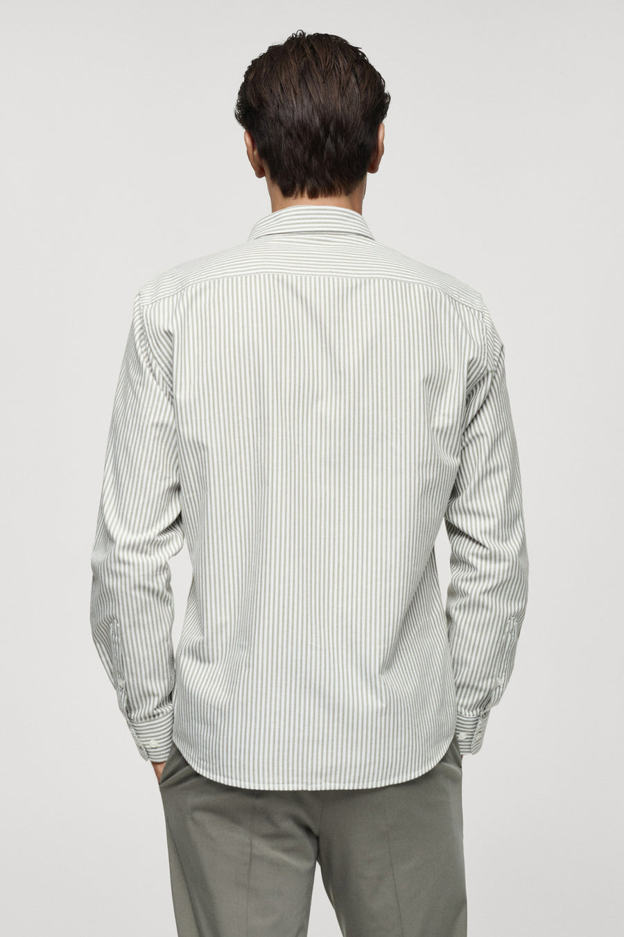 Groen overhemd met lange mouwen van MANGO, gestreept dessin, achterkant weergegeven, gecombineerd met een grijze broek.
