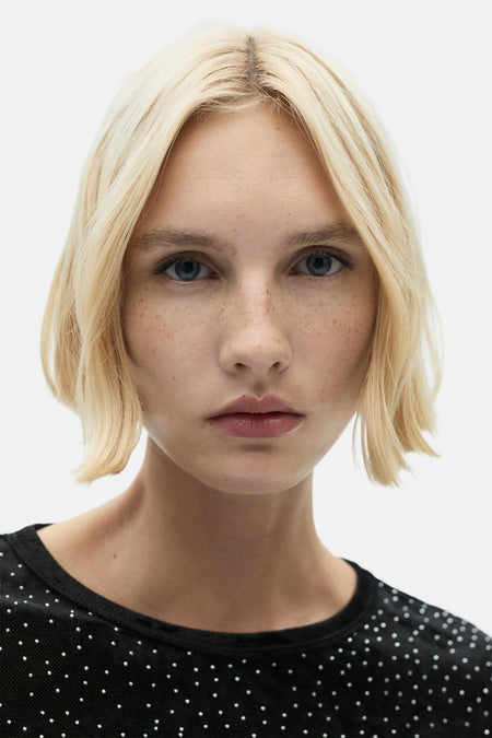 Zwart lange mouwen T-shirt met witte stippen, van MANGO, close-up op model met blond haar