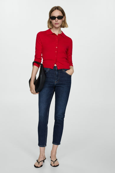Donkerblauwe mom jeans van MANGO, gecombineerd met een rode cardigan, zwarte tas en open schoenen met hakje.
