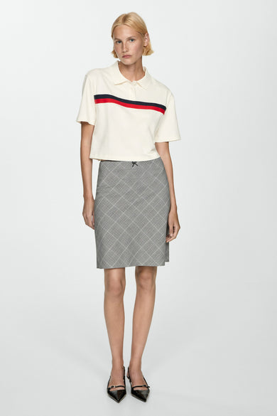 Witte polo met korte mouwen van MANGO, met rode en blauwe strepen op de borst.