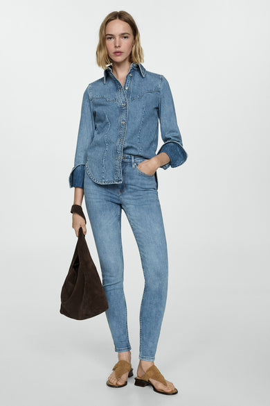 Skinny jeans van mid blue denim van MANGO, met een denim shirt met lange mouwen en een bruine tas.