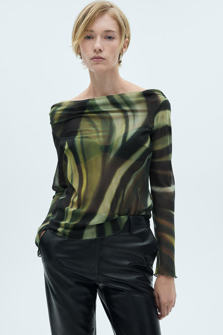 Multikleurige blouse met lange mouwen van MANGO, met een abstract golfpatroon en gedragen met een zwarte broek.
