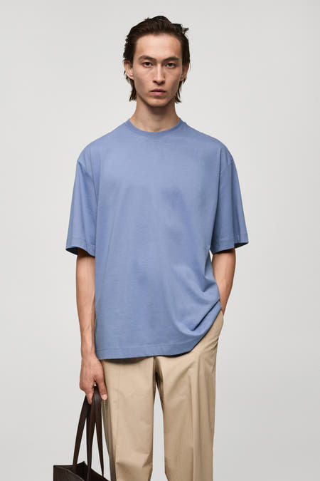 Paars T-shirt met korte mouwen van MANGO, gedragen met een beige pantalon en een bruine leren tas.
