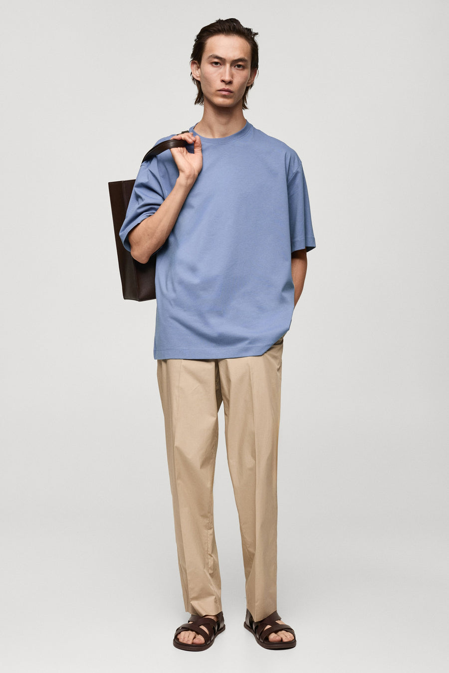 Paars T-shirt met korte mouwen van MANGO, met een tas over de schouder en een beige broek en sandalen.