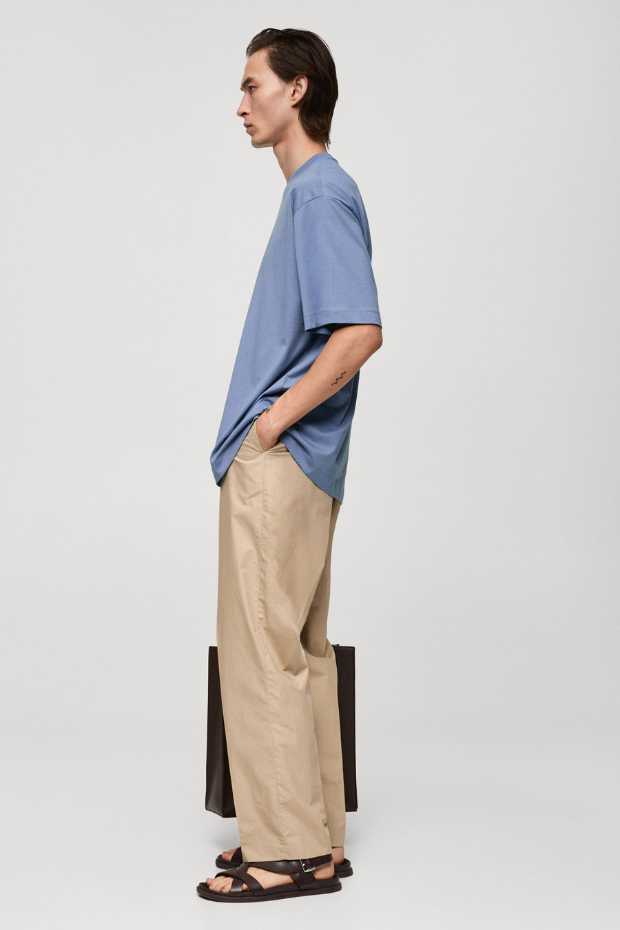 Paars T-shirt met korte mouwen van MANGO, gedragen met wijde, beige broek en bruine sandalen, zijaanzicht.
