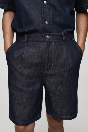 Denim jeansshort van MANGO, uitgevoerd in mid blue denim met plooien en steekzakken.
