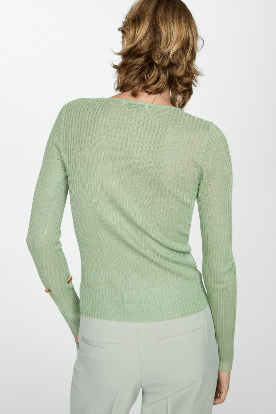 Groene trui met ronde hals van MANGO, met lange mouwen en ribgebreide textuur, gecombineerd met een pantalon.
