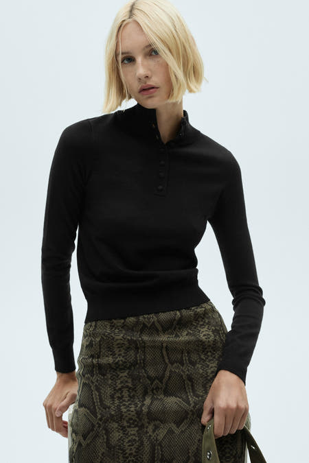 Veelkleurige trui met ronde hals van MANGO, met knoopdetail en gecombineerd met een rok met slangenprint.
