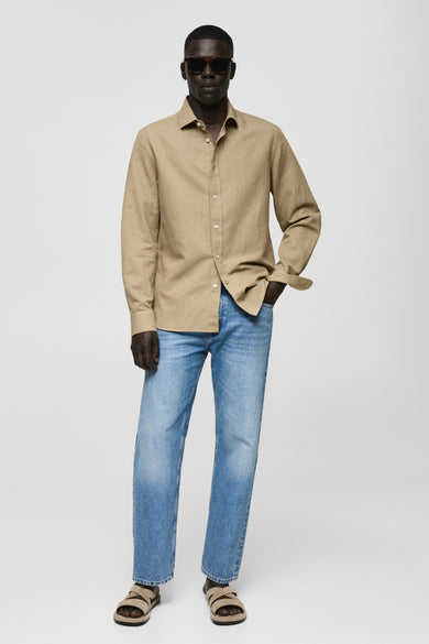 Groen hemd met lange mouwen van MANGO, gedragen met jeans en suède sandalen.