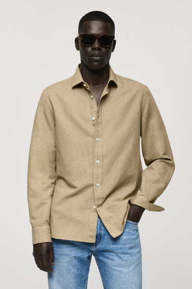 Groen hemd met lange mouwen van MANGO, gedragen met een open kraag en blauwe jeans.